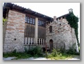 Plečnikova cerkev v Črni vasi na Barju od zadaj: v ogradi je popadljiv pes